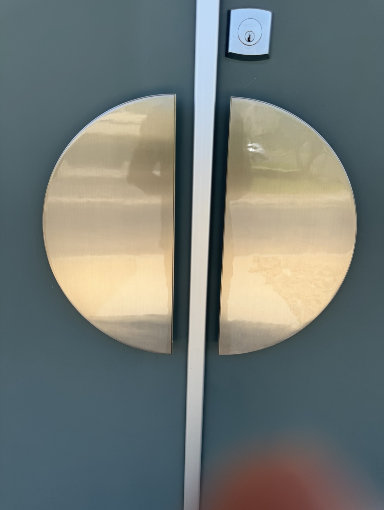 Polished and lacquer sealed brass entry door pulls after on-site brass restoration in the Coachella Valley